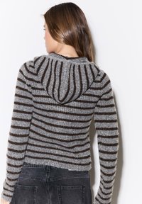 Kapuzensweater in Grau- und Braunstreifen mit strukturierter Stoffqualität, figurbetontem Schnitt und verkürzter Länge sowie langen Ärmeln.