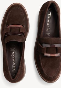 Mocassins en daim marron avec boucle décorative foncée, coutures visibles et semelles intérieures en cuir marquées "Tamaris" et taille 37.