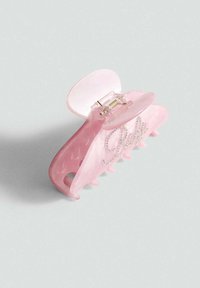 Šnala za kosu ružičaste boje od sjajnog plastike, s mehanizmom šarka i natpisom "Babe" od cirkona sprijeda. Teksturirani držač s zaobljenim zubima.