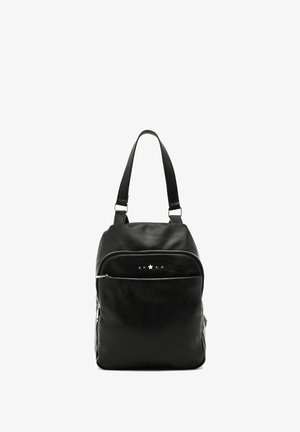 Mochila de cuero negro con forma redondeada, bolsillo frontal con cremallera y detalle de acento en forma de estrella. Cuenta con dos correas de hombro ajustables.
