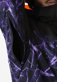 Zwarte en paarse jacket met een patroon en een ritszak, voorzien van een modern ontwerp en een soepele textuur, geschikt voor buitenshuis.