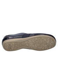 Black leather shoe with elastic side panels, featuring a beige rubber sole embossed with floral patterns and a sturdy design.