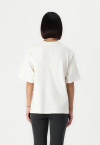 Afslappet fit, kortærmet t-shirt i off-white bomuld med rund hals. Glat tekstur, enkelt design og ingen synlige mønstre.