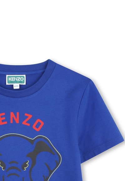 T-shirt en coton bleu avec un graphisme d'éléphant, texte "KENZO" rouge et manches courtes. Encolure ronde avec texture lisse.