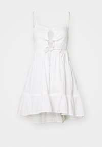 Vestido de sol blanco con tirantes finos ajustables, corte en forma de llave en el busto, cintura elástica y falda acampanada de volantes. Tejido ligero.