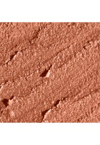 Geperst poeder in een warme koraalkleur met een glanzende afwerking, voorzien van een gestructureerd oppervlak en fijne deeltjes voor een gelijkmatige toepassing.