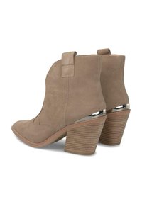Botas de ante marrón hasta el tobillo con punta afilada, un tacón alto apilado con estrías horizontales y lengüetas en la parte posterior para ponérselas fácilmente.