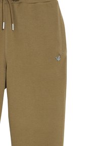 Braune Jogginghosen mit Textur, elastischem Bund, Kordelzug und einem kleinen silbernen Logoakzent am Oberschenkel. Mit Seitentaschen.