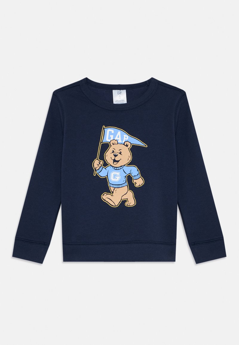 Námornícky modré mikina vyrobená z bavlnenej zmesi, s postavičkou medveďa držiaceho modrú vlajku s tlačeným textom "GAP" v svetlomodrej farbe.