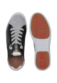 Sneakers in pelle nera e feltro grigio con dettagli argentati, caratterizzati da una suola testurizzata, lacci rotondi e il marchio "CRICKIT" in rosso sulla suola.