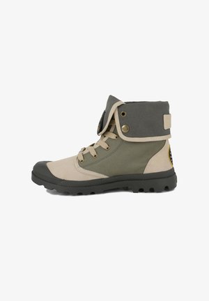 Bottes de randonnée avec une tige en toile beige et textile vert, semelle en caoutchouc, œillets dorés et un col gris repliable.