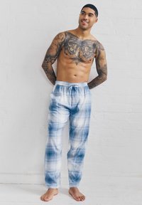 Pantalons de pyjama à carreaux bleus et blancs avec une taille élastique et un cordon de serrage, en tissu léger et lisse avec une coupe décontractée.
