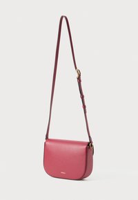 Borsa crossbody in pelle rossa con texture, dalla forma arrotondata, fronte piatto e tracolla regolabile. Presenta dettagli in metallo dorato e branding.