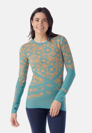 Long-sleeve sweater made of teal fabric featuring an orange floral pattern. Round neckline and fitted design with textured accents on sleeves.