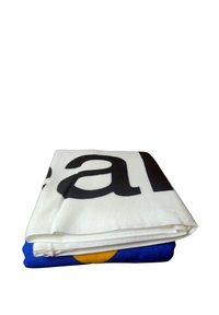 Vouwstof met een grote zwarte print op een witte ondergrond, laag over een blauwe achtergrond met een gele cirkelontwerp.