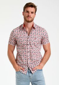 Korte mouwen, knoopshirt in een veelkleurig geometrisch patroon met roze, marineblauw en wit. Voorzien van een contrasterende oranje kraag.