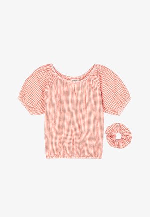 Blusa de cuadros rojos y blancos con mangas abullonadas y escote redondeado, acompañada de una goma para el pelo a juego. Tela de algodón, diseño fruncido.