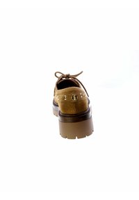 Scarpe in suede marrone con punta arrotondata, suola piatta spessa marrone e accenti decorativi in metallo dorato sul retro.
