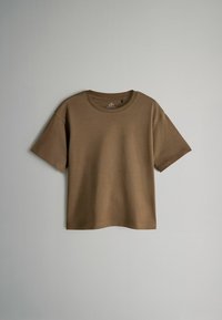 Camiseta de manga corta marrón hecha de una tela suave; cuello redondo; corte relajado; textura lisa; sin patrones o herrajes visibles.