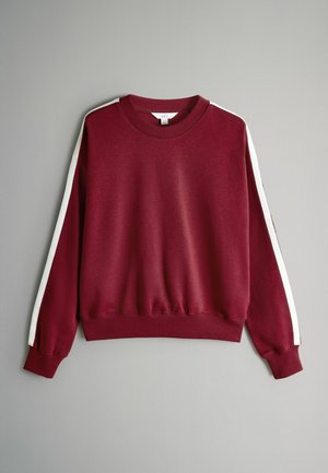 Vīnogu krāsas džemperis ar baltām sānu svītrām, ribotas apakšmalas, apkakles un aproču detaļas. Mīksts audums ar brīvu piegriezumu un garām piedurknēm.