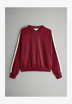 Vīnogu krāsas džemperis ar baltām sānu svītrām, ribotas apakšmalas, apkakles un aproču detaļas. Mīksts audums ar brīvu piegriezumu un garām piedurknēm.