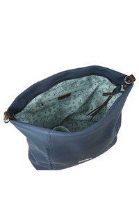 Bolso de lona en azul marino con un exterior texturizado, que incluye un interior de tela con un patrón azul claro, un bolsillo con cremallera y acentos de cuero.