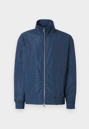 Marineblå zip-jakke med gentagende "MK" logo mønster over det hele, høj krave, elastiske manchetter og sølv dobbelte lynlås foran.