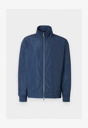 Navy blue zip-up jacket with all-over repeating "MK" logo pattern, high collar, elastic cuffs, and silver double zipper on the front.