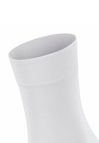 Calzino bianco con polsino a coste, realizzato in un materiale liscio e elasticizzato. Presenta un design senza cuciture e una forma leggermente affusolata alla caviglia.