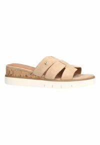 Beige suède slidesandaal met kruislings straps, kurken middenzool en een witte rubberen buitenzool met horizontale groeven.