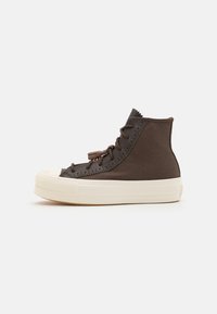 Brun högstövel sneakers gjorda av texturerat material, med en vit gummisula, rund tå och bruna skosnören med perforerade accenter.