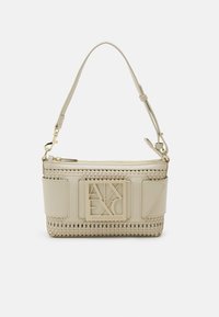 Beżowa torebka o plecionej fakturze, z paskiem wykonanym ze skóry i dużym logo na przedniej części. Zapięcie na suwak oraz gładkie wykończenie detali.