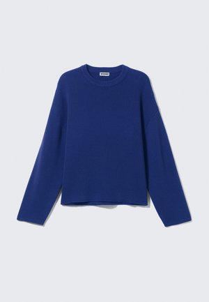 Blauwe gebreide trui met een ronde halslijn, verlaagde schouders en lange mouwen. Vlotte textuur en een cropped onderkant. Labels zichtbaar aan de binnenkant van de hals.