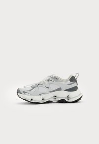 Sneakers sport cu o partea superioară din plasă albă cu accente gri, o talpă intermediară albă robustă și o talpă exterioară din cauciuc negru.