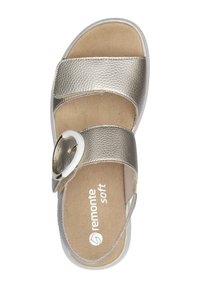Gold textured sandal with two wide straps, circular white accent, and cushioned tan insole. Flexible white sole for comfort.