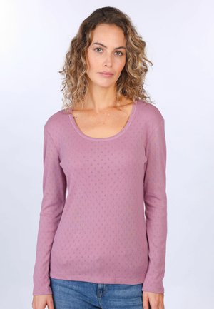 Langärmliges Shirt mit Rundhalsausschnitt in hellem Mauve mit einem strukturierten Muster aus kleinen Rauten. Weicher Stoff mit dezentem Glanz, kombiniert mit blauen Jeans.