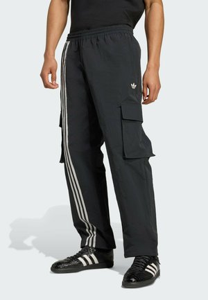 Zwarte cargo pants met elastische tailleband, voorzien van drie witte strepen langs de zijkanten en cargozakken. Gemaakt van lichtgewicht materiaal.