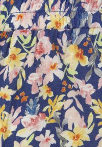 Gėlių audinys su tamsiai mėlynu fonu, kuriame yra rožinių, geltonų ir baltų gėlių. Tekstūra su tampri, raukšlėta paviršiumi.