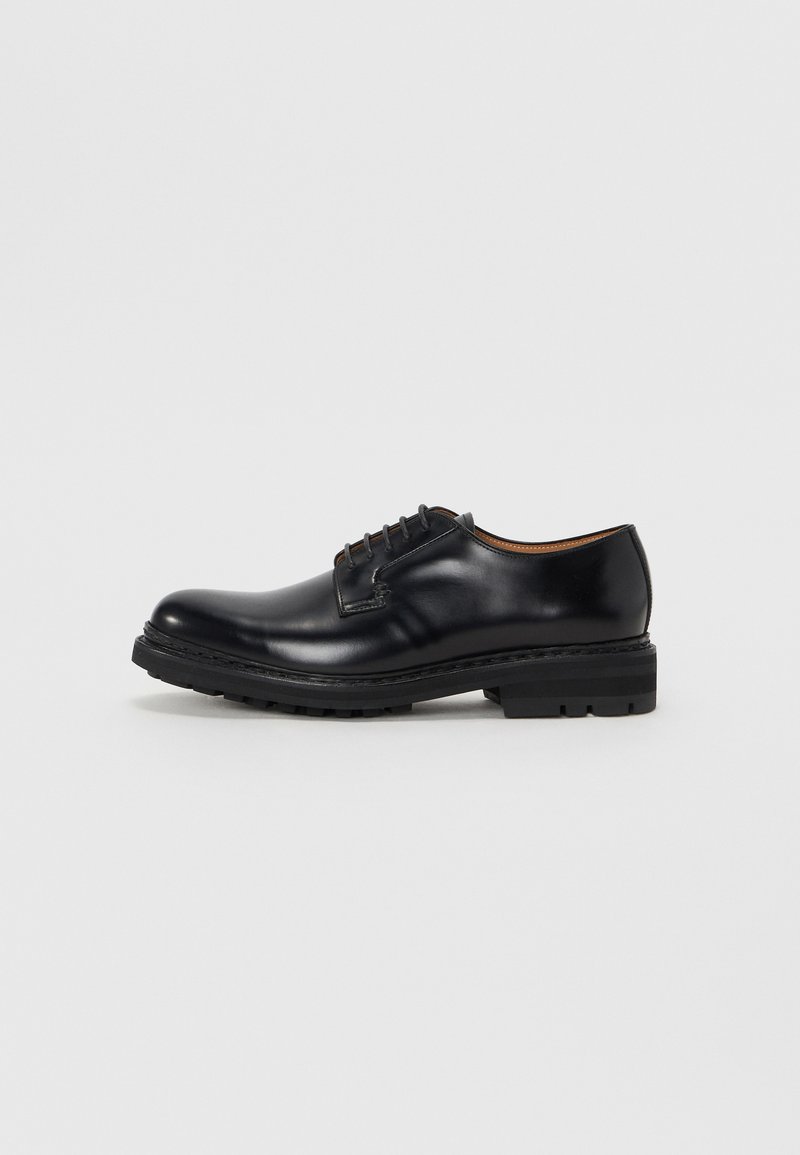 Black leather dress shoe with rounded toe, low heel, and lacing. Features smooth texture and minimal stitching detail. Rubber outsole.