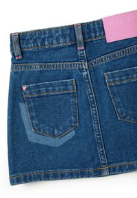 Minifalda de mezclilla en azul oscuro con un ligero desvanecimiento, diseño de cinco bolsillos, costuras rosas y un acento de corazón en el bolsillo trasero.