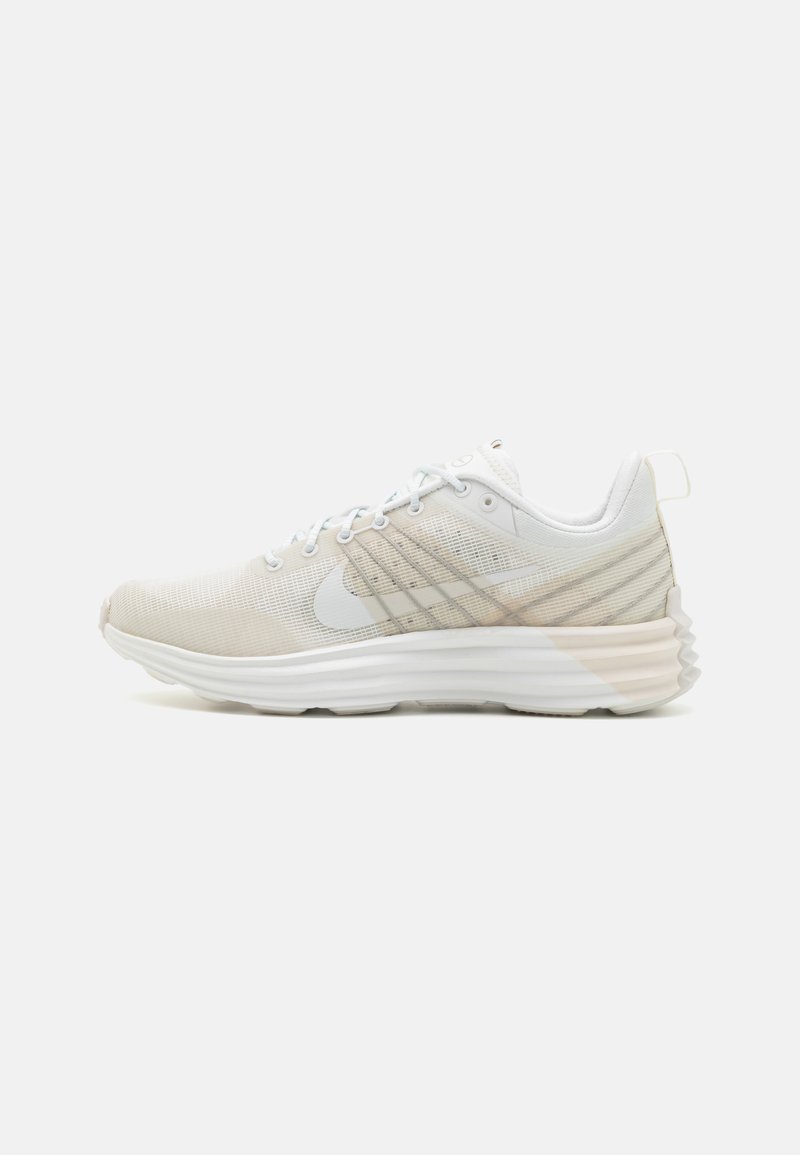 Scarpa da corsa leggera in mesh bianco e beige chiaro, caratterizzata da una suola ammortizzata, design con lacci e sottili strisce decorative sulla parte superiore.