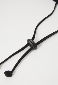Black cord with a smooth plastic adjuster, featuring two ends tied in knots. The texture is woven, with a consistent thickness throughout.