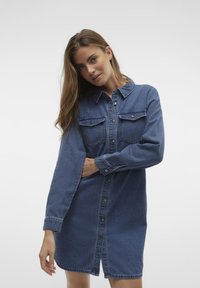Denim skjortklänning i mellanblått, med knapp-up framsidan, två bröstfickor, långa ärmar och rak skärning med sidofickor.