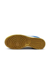 Nike sneaker sole in gum rubber with textured tread patterns; features bold blue upper, white accents, and distinct circular logo detail.