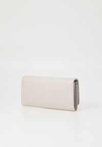 Portafoglio in pelle texturizzata, beige chiaro, con un design elegante e allungato e un interno grigio, dotato di una chiusura semplice e una cucitura discreta.