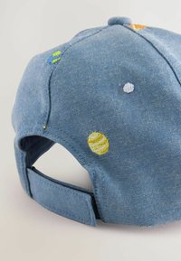Jeanskepp med broderade planeter i gult, grönt och vitt. Har en böjd skärm och justerbar rem bak.