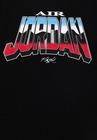 Czarny t-shirt z tkaniny z odważnym, kolorowym nadrukiem "AIR JORDAN" z niebieskimi, białymi i czerwonymi akcentami oraz podpisem poniżej.