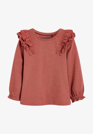 Langærmet top i støvet rosa til små børn med blonderynker på skuldrene og elastiske manchetter.