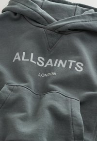 Felpa grigia con cappuccio e tasca a marsupio, con la scritta "ALLSAINTS" sopra "LONDON" in bianco, e cappuccio dalla texture particolare. Tessuto morbido.
