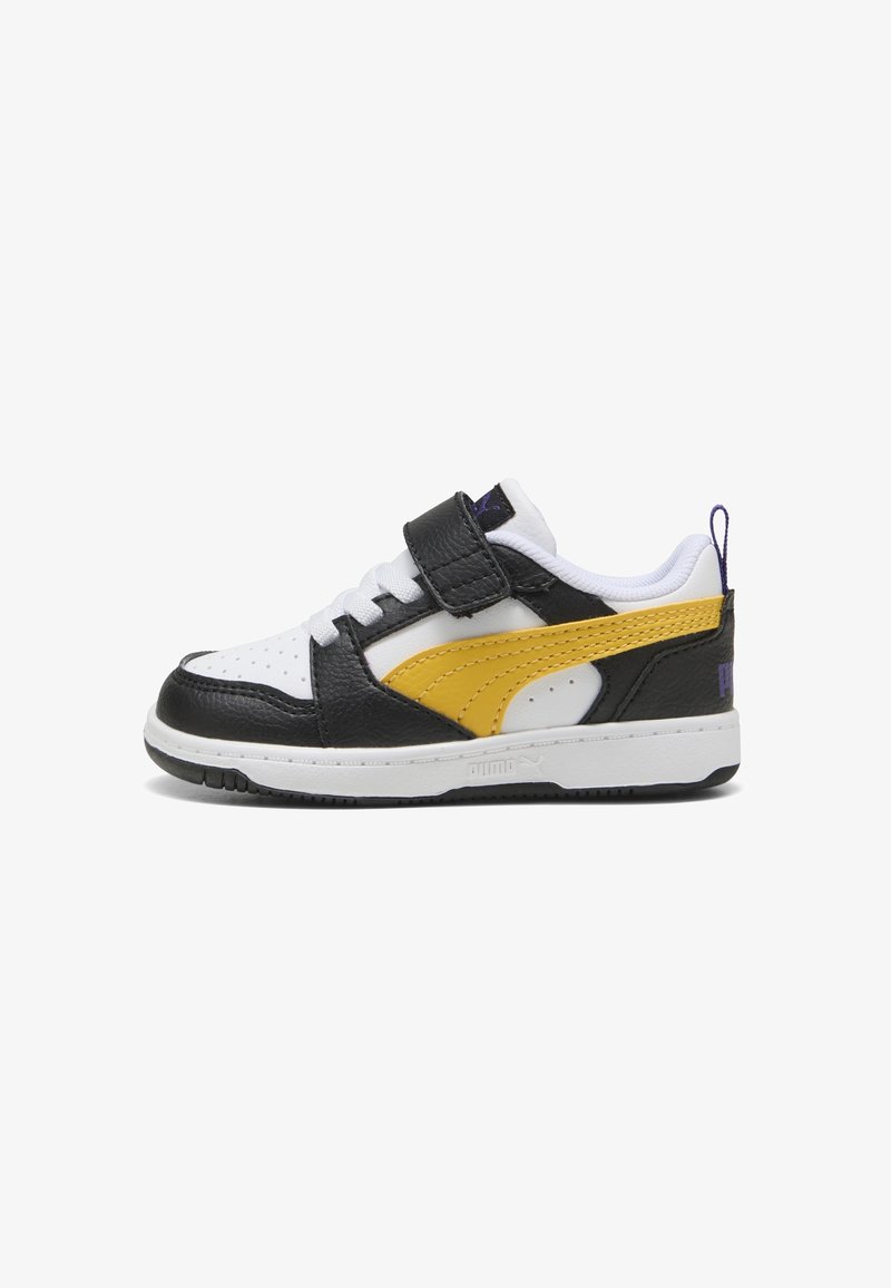 Baskets basses en cuir noir et blanc, bande latérale jaune, lacets blancs et fermeture Velcro noire, conçues pour enfants.